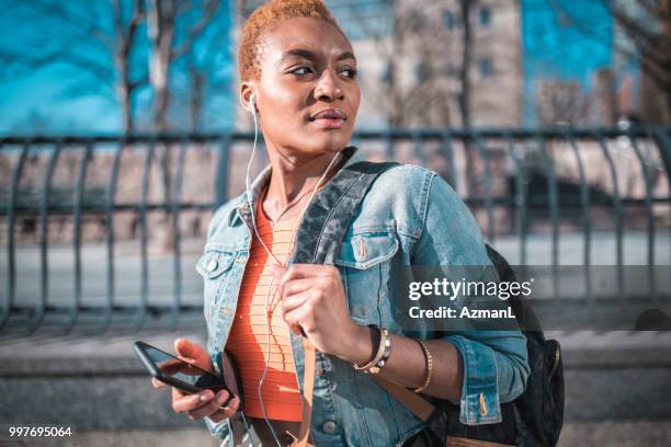 jonge vrouw houden van mobiele telefoon en luisteren naar muziek - fashion pretty woman listening music in headphones with smartphone colorful stockfoto's en -beelden