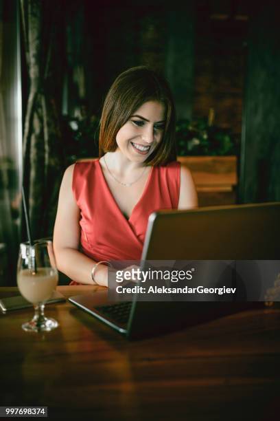 entzückend weiblich über videokonferenz auf laptop in der bar - aleksandar georgiev stock-fotos und bilder