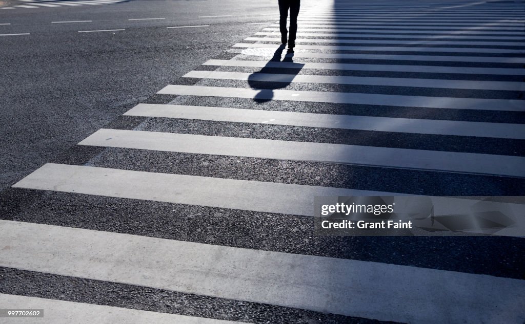 Man walking across large intersection.