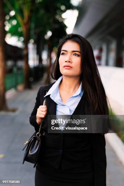 retrato de una mujer asiática joven parado en medio de la calle. - vanguardista fotografías e imágenes de stock