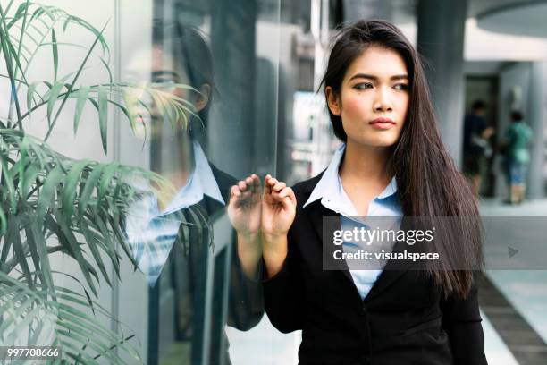 retrato de uma jovem mulher asiática, encostado a uma parede de vidro. - vanguardians - fotografias e filmes do acervo