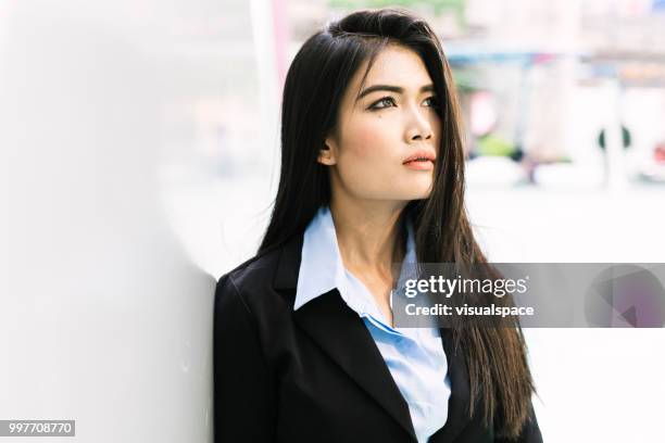 retrato de uma jovem mulher asiática, encostado a uma parede, olhando para cima. - vanguardians - fotografias e filmes do acervo