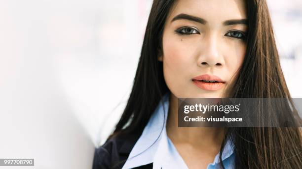 porträtt av en ung asiatisk kvinna lutad mot en vägg. - letterbox bildbanksfoton och bilder