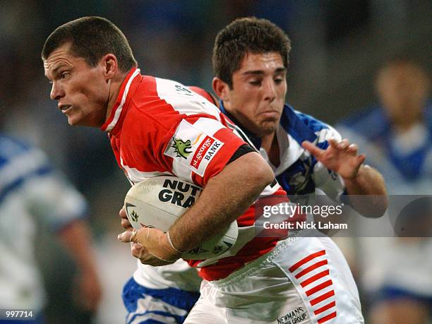 Darren Treacy of the Dragons attempts to break the tackle of Braith Anasta of the Bulldogs during the NRL qualifying final between the Bulldogs and...