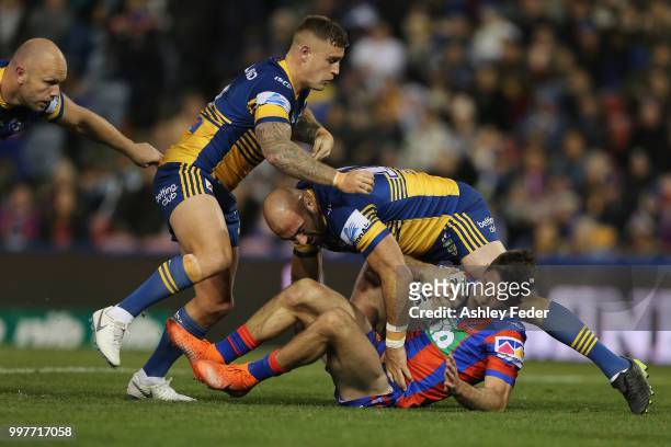 Nick Meaney of the Knights is tackled by the Eels defence during the round 18 NRL match between the Newcastle Knights and the Parramatta Eels at...