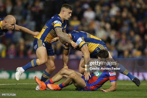 Nick Meaney of the Knights is tackled by the Eels defence during the round 18 NRL match between the Newcastle Knights and the Parramatta Eels at...