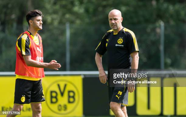 Dortmund's coach Peter Bosz gives his player Mahmoud Dahoud instructions during the training camp of German soccer club Borussia Dortmund in Bad...