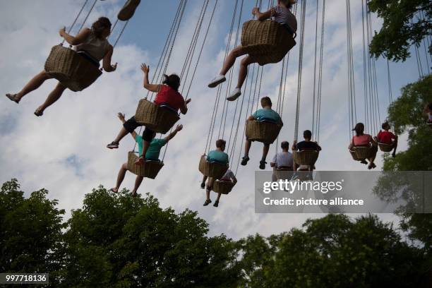 Visitors take a ride on a chairoplane at the adventure park Tripsdrill in Cleebronn, Germany, 31 July 2017. Photo: Marijan Murat/dpa