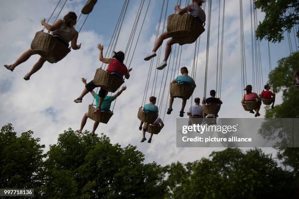 Visitors take a ride on a chairoplane at the adventure park Tripsdrill in Cleebronn, Germany, 31 July 2017. Photo: Marijan Murat/dpa