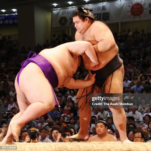 Takakeisho pushes ozeki Takayasu out of the ring to win on day six of the Grand Sumo Nagoya Tournament at the Dolphin's Arena on July 13, 2018 in...