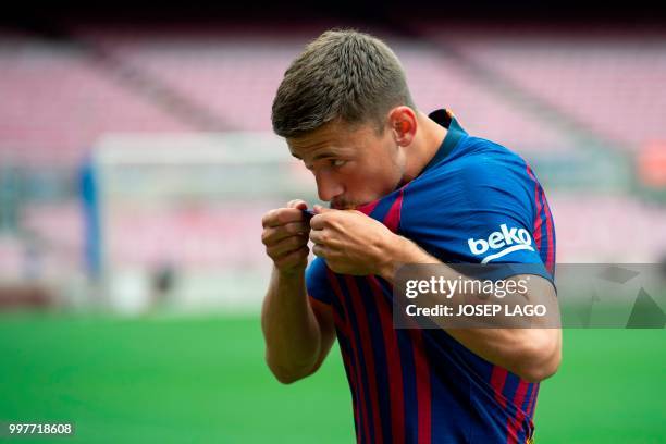 Barcelona's new player French defender Clement Lenglet kisses his new jersey during his official presentation at the Camp Nou stadium in Barcelona on...