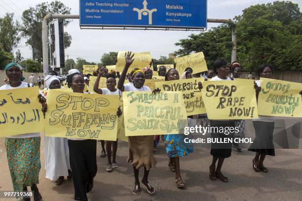 Women march carrying placards with messages demanding peace and their rights, on the streets of South Sudan's capital, Juba on July 13 following...