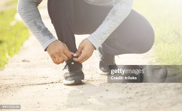 jogger tying shoelace - low section stock pictures, royalty-free photos & images