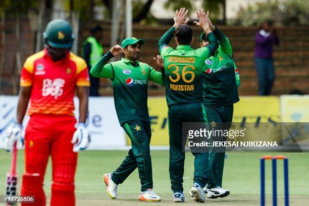 Pakistan's Usman Khan celebrates with teammates after taking a wicket during the first one day international cricket match between Pakistan and...