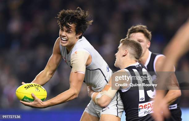 Jack Silvagni of the Blues handballs whilst being tackled by Jack Lonie of the Saints during the round 17 AFL match between the St Kilda Saints and...