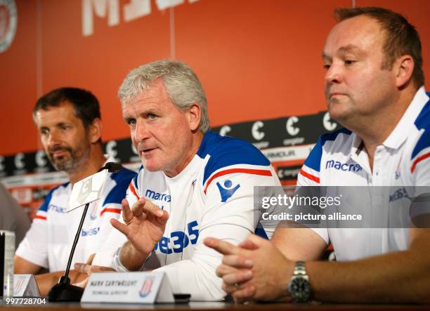 English Premier League club Stoke City's CEO Tony Scholes, manager Mark Hughes, and technical director Mark Cartwright at a press conference at which...