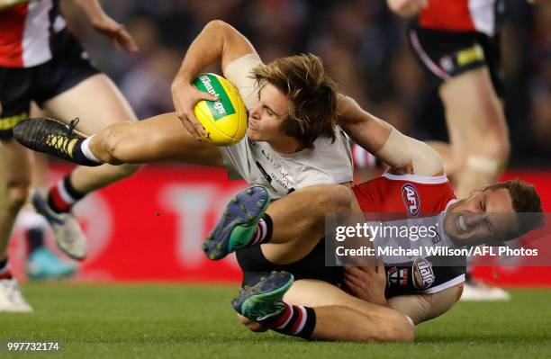 Cameron Polson of the Blues is tackled by Luke Dunstan of the Saints during the 2018 AFL round 17 match between the St Kilda Saints and the Carlton...
