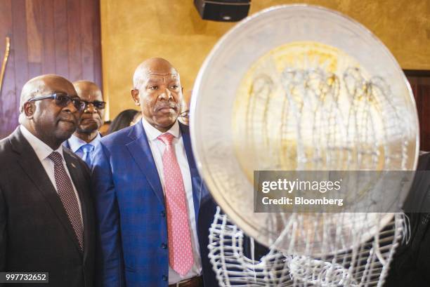 Nhlanhla Nene, South Africa's finance minister, left, and Lesetja Kganyago, governor of South Africa's reserve bank inspect a display of...