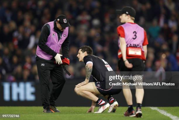 Jake Carlisle of the Saints is treated by trainers during the 2018 AFL round 17 match between the St Kilda Saints and the Carlton Blues at Etihad...