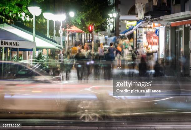 Ghost-like appear vehicles and pedestrians captured by a 10-second long exposure shot while they walk along the Pauls Square in downtown Frankfurt am...