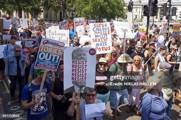 Protesters against the UK visit of US President Donald Trump hold up placards as they take part in a march and rally in London on July 13, 2018. -...