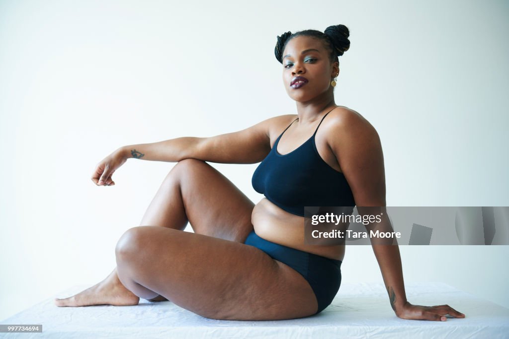 Confident curvy woman sitting and looking to camera
