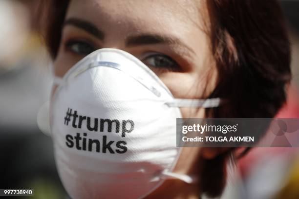 Protester against the UK visit of US President Donald Trump wearing a face mask with an anti-Trump message joins thousands of others to take part in...