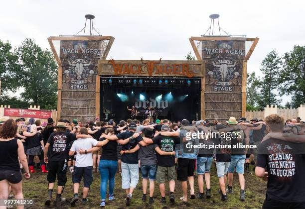 Festival-goers dance arm in arm in front of the Wackinger Stage at the Wacken Open Air Festival in Wacken, Germany, 02 August 2017. The Wacken Open...