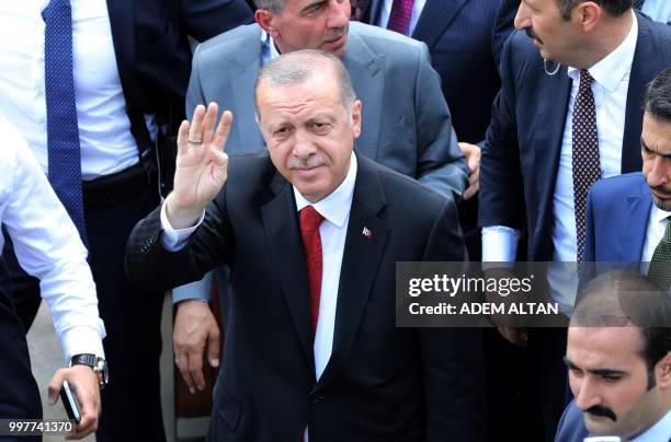 Turkey's President Recep Tayyip Erdogan waves as he walks with members of the Presidential Cabinet greet the crowd after performing Friday Prayer at...