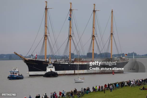 Numerous spectators watch how the "Peking" museum ship is towed by two tugs along the Elbe where it meets the Stor river near Wewelsfleth, Germany,...