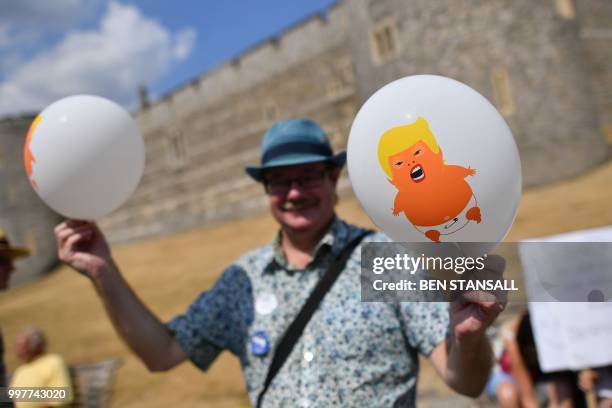 Protester against the visit of US President Donald Trump holds a balloon with a picture of an image depicting Trump as an orange baby outside Windsor...