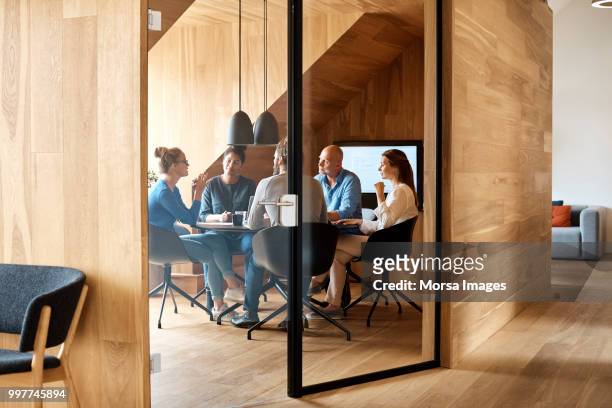 business executives discussing in office meeting - kleine personengruppe stock-fotos und bilder