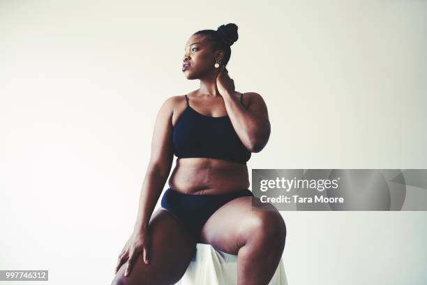 curvy woman underwear sitting on stool - black pants stock pictures, royalty-free photos & images