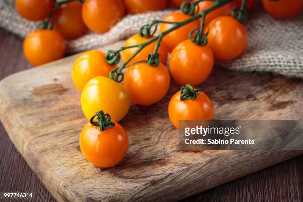 fresh orange cherry tomatoes - tomate amarillo fotografías e imágenes de stock