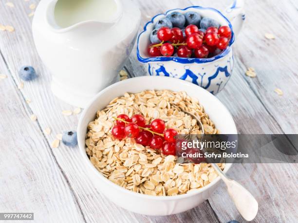 raw oats with berries on table - macrobiotic diet stock pictures, royalty-free photos & images
