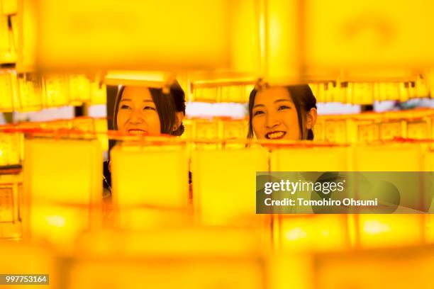 Women look at lit paper lanterns during the Mitama Matsuri summer festival at the Yasukuni Shrine on July 13, 2018 in Tokyo, Japan. The four-day...