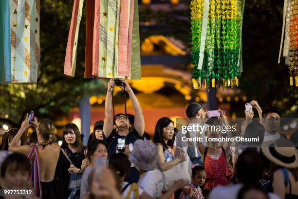 People take photographs of lit paper lanterns during the Mitama Matsuri summer festival at the Yasukuni Shrine on July 13, 2018 in Tokyo, Japan. The...