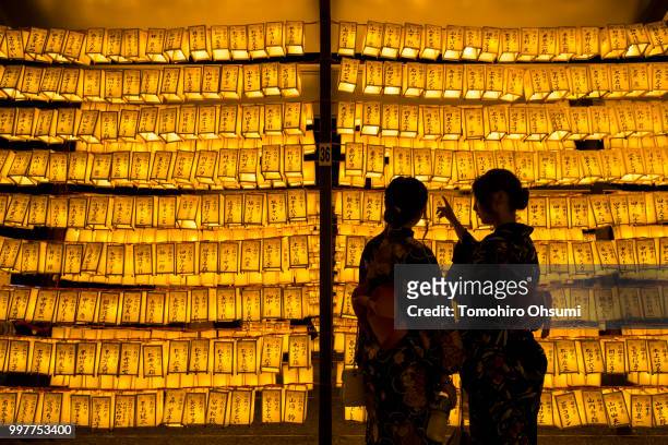Women look at lit paper lanterns during the Mitama Matsuri summer festival at the Yasukuni Shrine on July 13, 2018 in Tokyo, Japan. The four-day...