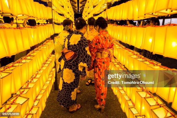 Women check a smartphone after taking a photograph during the Mitama Matsuri summer festival at the Yasukuni Shrine on July 13, 2018 in Tokyo, Japan....