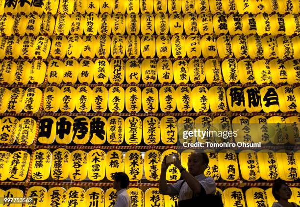 People walk past lit paper lanterns during the Mitama Matsuri summer festival at the Yasukuni Shrine on July 13, 2018 in Tokyo, Japan. The four-day...