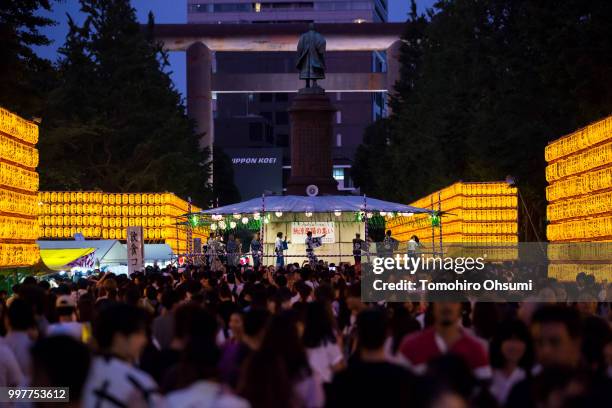 People dance on a stage in front of lit paper lanterns during the Mitama Matsuri summer festival at the Yasukuni Shrine on July 13, 2018 in Tokyo,...