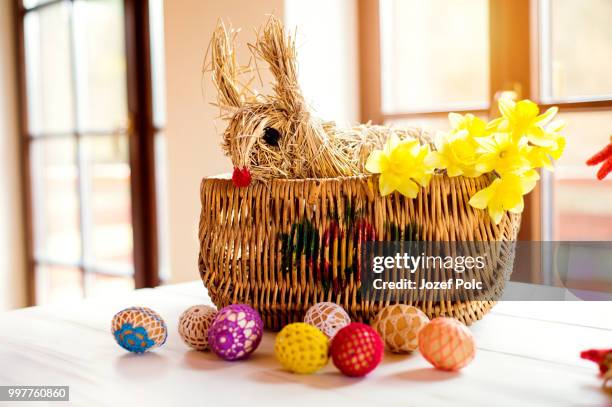 wicker basket, straw easter bunny and daffodils, crocheted eggs - empty easter basket stock pictures, royalty-free photos & images