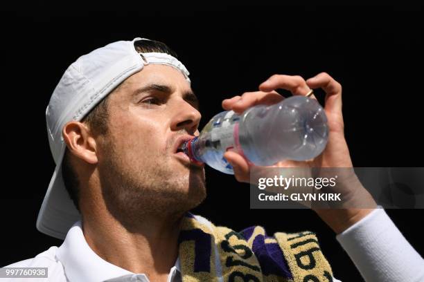 Player John Isner takes a drink during a break in play against South Africa's Kevin Anderson during their men's singles semi-final match on the...