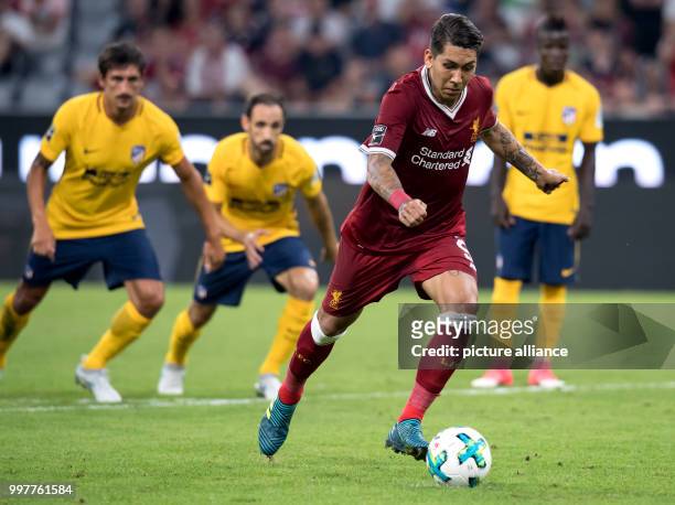 Liverpool's Roberto Firmino converts a penalty kick to level the score at 1:1 during the Audi Cup final soccer match between Atletico Madrid and FC...