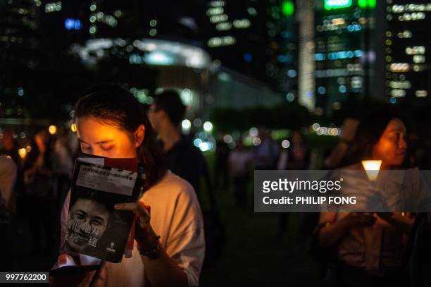 People light up candles at a memorial event outside Tamar Park in Hong Kong on July 13 to mark the first anniversary of the death of late Chinese...
