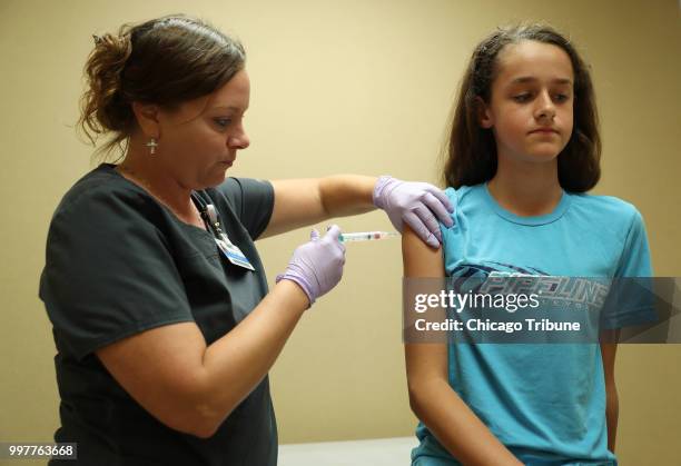 Nurse Laura Johnson administers a dose of the human papillomavirus vaccine to Abby Major at an Amita Health clinic Tuesday, July 3 in Hoffman...