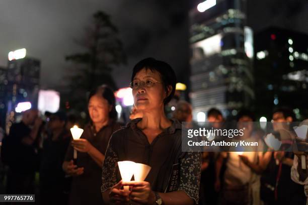 Vigil participants holding candles as they take part of a memorial vigil held for Chinese Nobel Peace Prize-winner Liu Xiaobo on July 13, 2018 in...