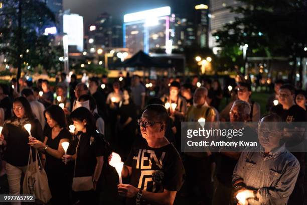 Vigil participants holding candles as they take part of a memorial vigil held for Chinese Nobel Peace Prize-winner Liu Xiaobo on July 13, 2018 in...