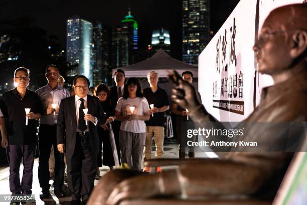 Vigil participants holding candles as they take part of a memorial vigil held for Chinese Nobel Peace Prize-winner Liu Xiaobo on July 13, 2018 in...