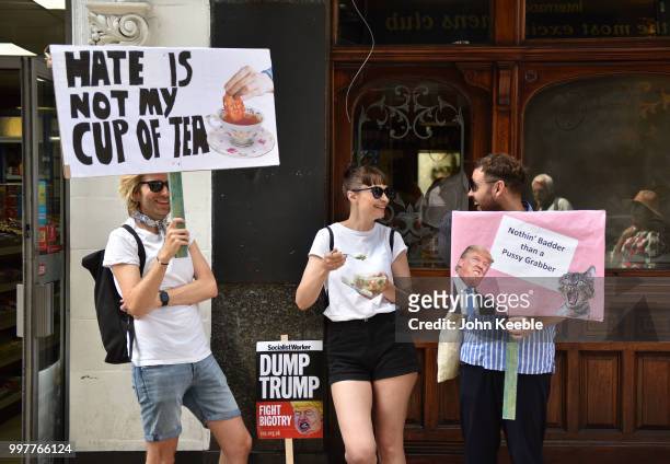 Demonstrators with an anti Trump placards saying "Dump Trump Fight Bigotry", "Hate is not my cup of tea" and "Nothing badder than a pussy grabber"...
